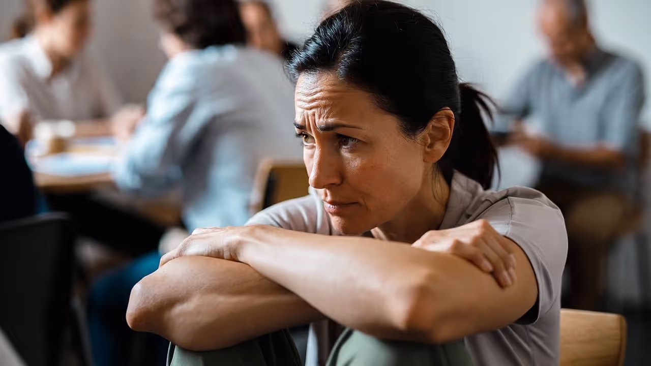 Adult showing hunched posture and lowered gaze associated with low self-esteem